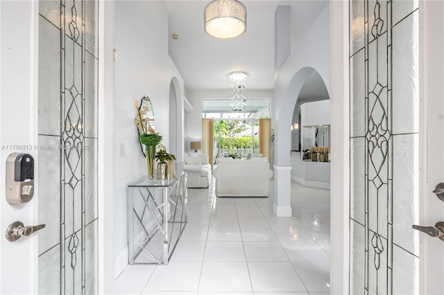 tiled entryway with baseboards and arched walkways