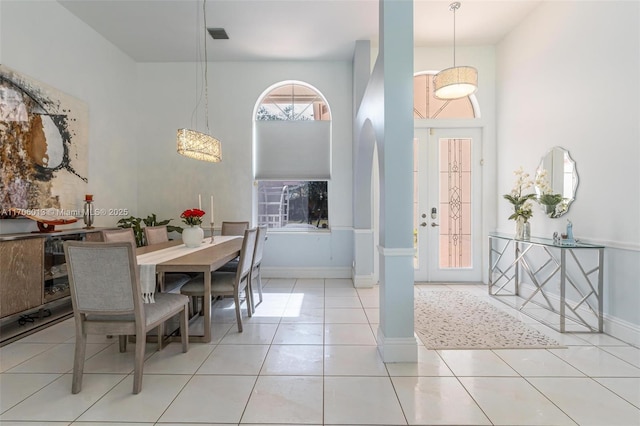 dining area featuring a high ceiling and light tile patterned floors