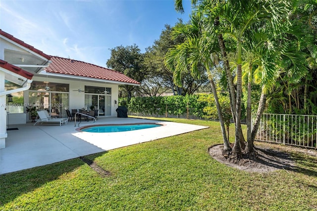 view of pool with a patio area, a lawn, and ceiling fan