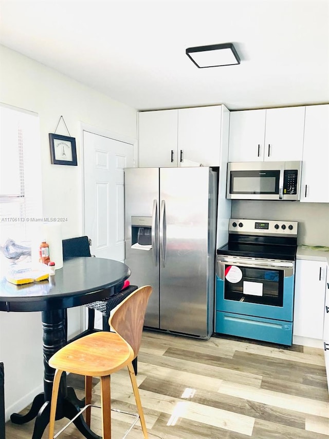 kitchen with white cabinetry, appliances with stainless steel finishes, and light hardwood / wood-style flooring