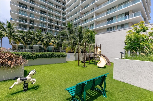 view of community featuring a playground and a lawn