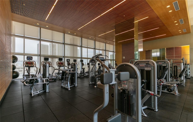 workout area featuring a towering ceiling and a wall of windows