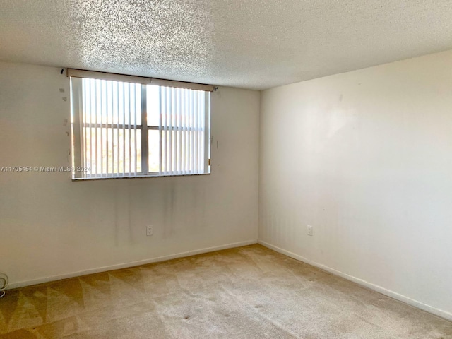 empty room featuring a textured ceiling and light carpet