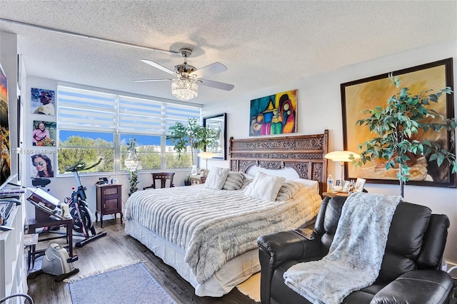 bedroom with a textured ceiling, dark hardwood / wood-style flooring, and ceiling fan