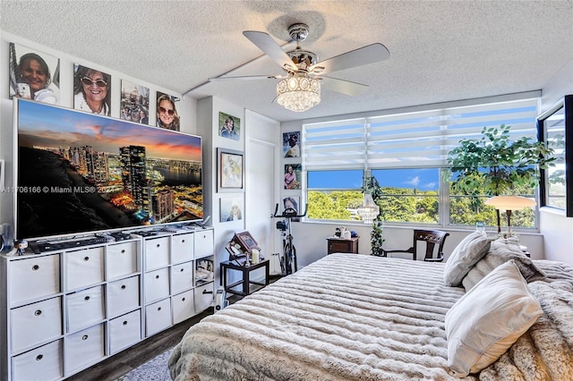 bedroom featuring multiple windows, ceiling fan, dark hardwood / wood-style flooring, and a textured ceiling