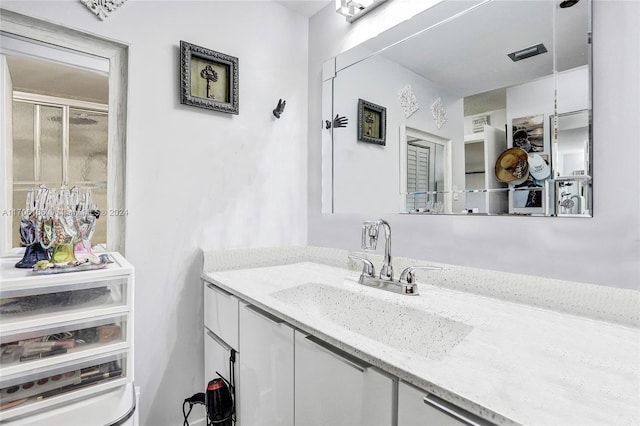 bathroom with vanity and a shower with shower door