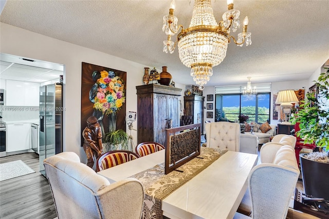 dining space with hardwood / wood-style floors, a textured ceiling, and a notable chandelier