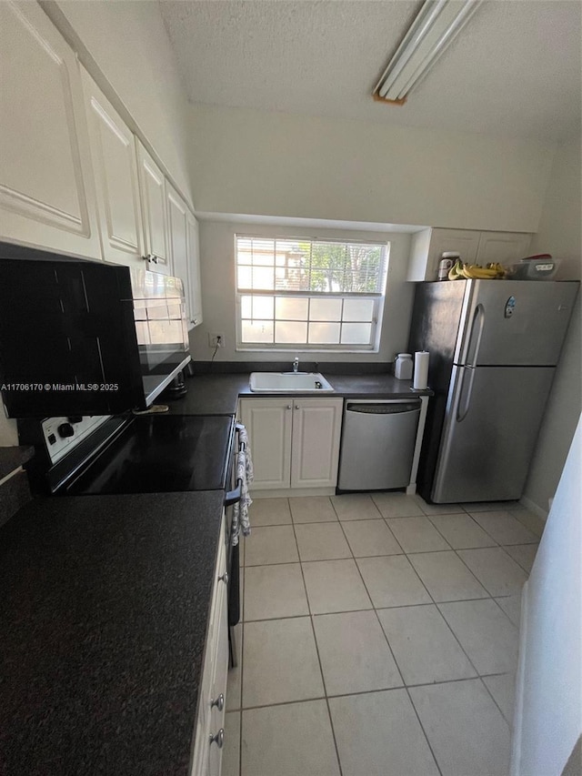 kitchen with white cabinetry, sink, a textured ceiling, light tile patterned floors, and appliances with stainless steel finishes