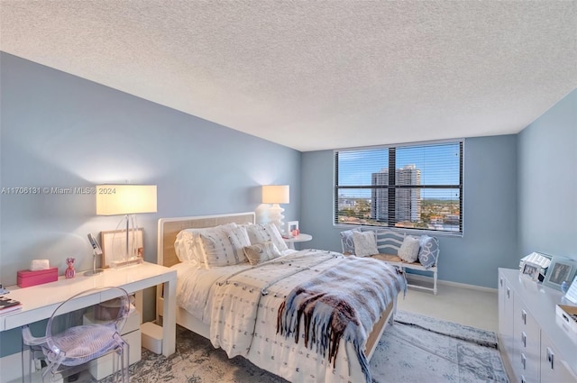 bedroom with light colored carpet and a textured ceiling