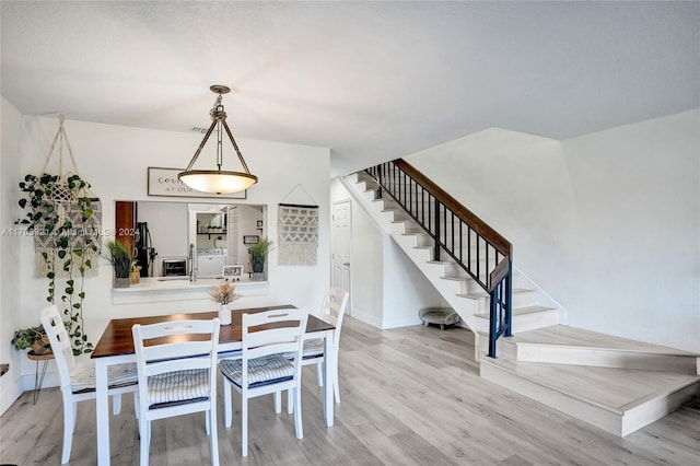 dining area with washing machine and dryer and light wood-type flooring