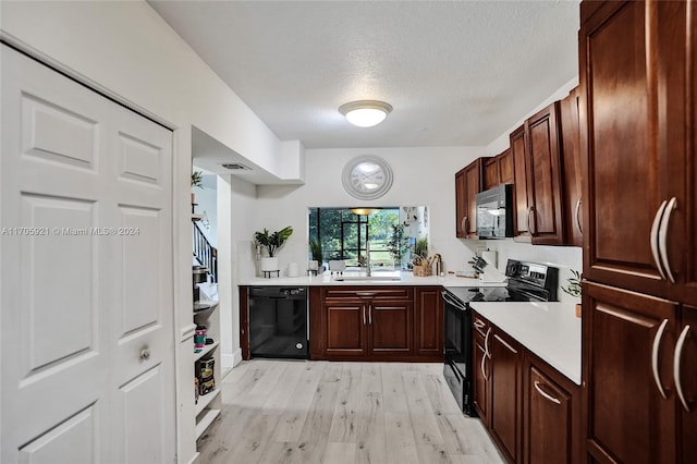 kitchen with sink, a textured ceiling, light hardwood / wood-style floors, and black appliances