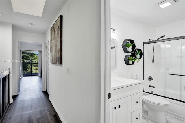 full bathroom featuring hardwood / wood-style flooring, vanity, toilet, and enclosed tub / shower combo