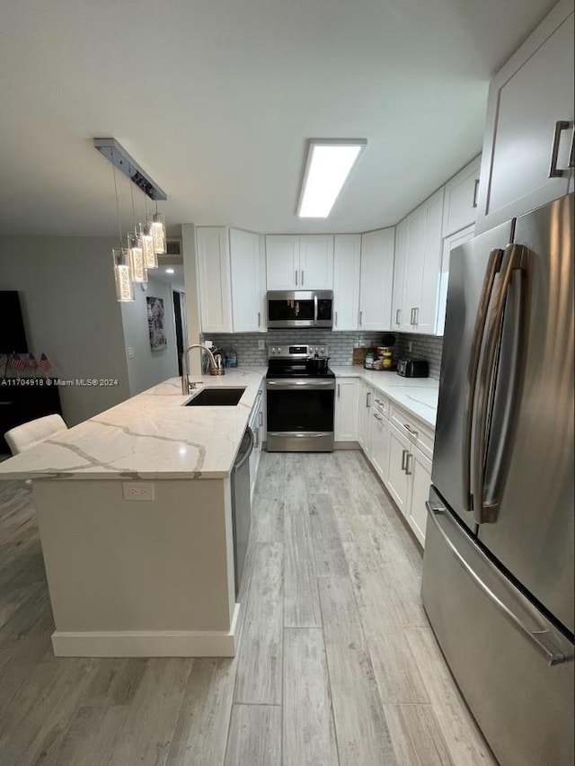 kitchen featuring white cabinets, light stone counters, and appliances with stainless steel finishes