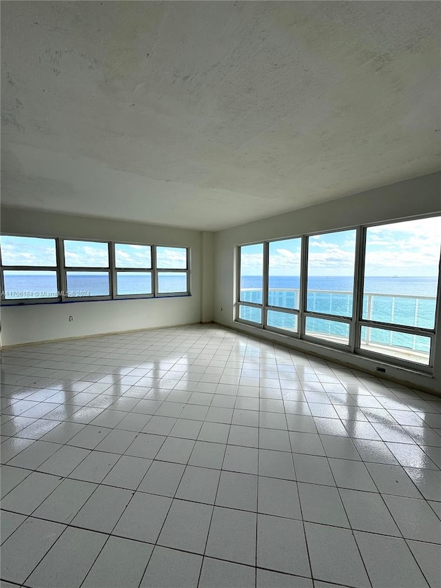 tiled spare room with a water view