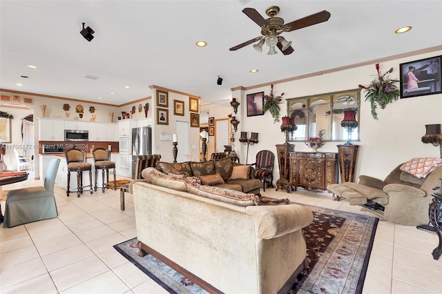 tiled living room featuring ceiling fan and crown molding