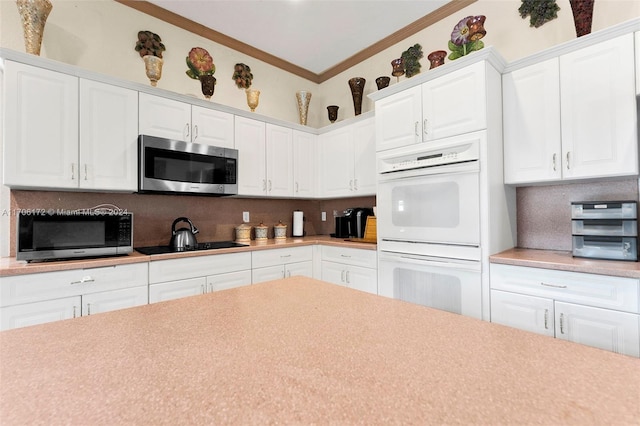 kitchen featuring double oven, backsplash, crown molding, black electric cooktop, and white cabinets