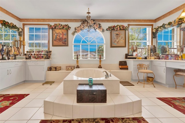 bathroom with a notable chandelier, a bathtub, tile patterned floors, and vanity