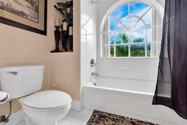 bathroom featuring tile patterned flooring, toilet, and tub / shower combination