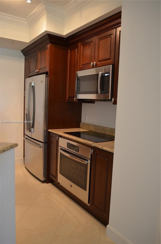 kitchen with light stone countertops, appliances with stainless steel finishes, a textured ceiling, crown molding, and light tile patterned flooring