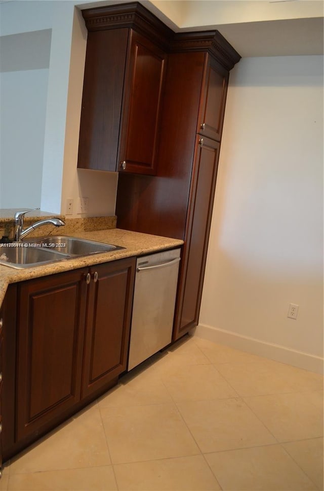 kitchen featuring dark brown cabinetry, dishwasher, sink, and light tile patterned flooring