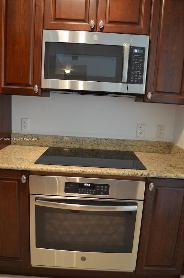 kitchen with light stone countertops and appliances with stainless steel finishes