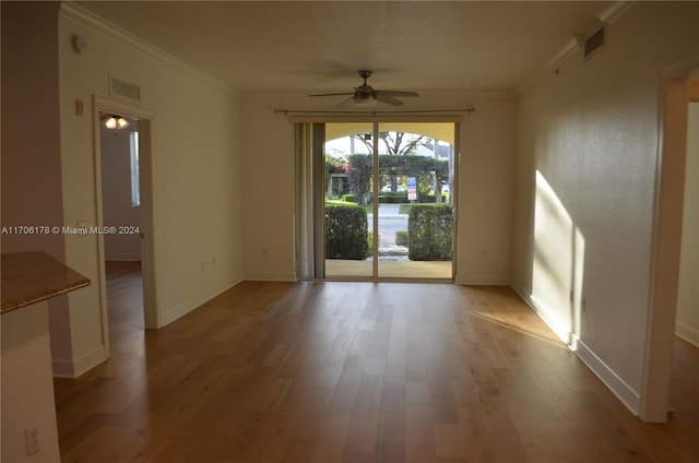 spare room featuring ceiling fan, light wood-type flooring, and crown molding