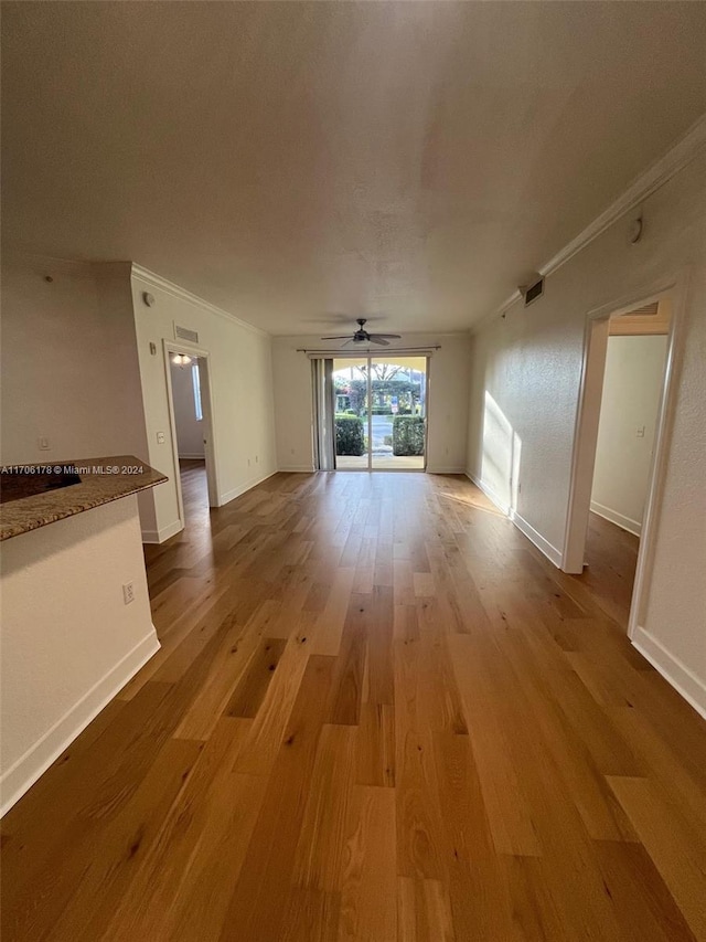 unfurnished living room with light hardwood / wood-style flooring, ceiling fan, and crown molding