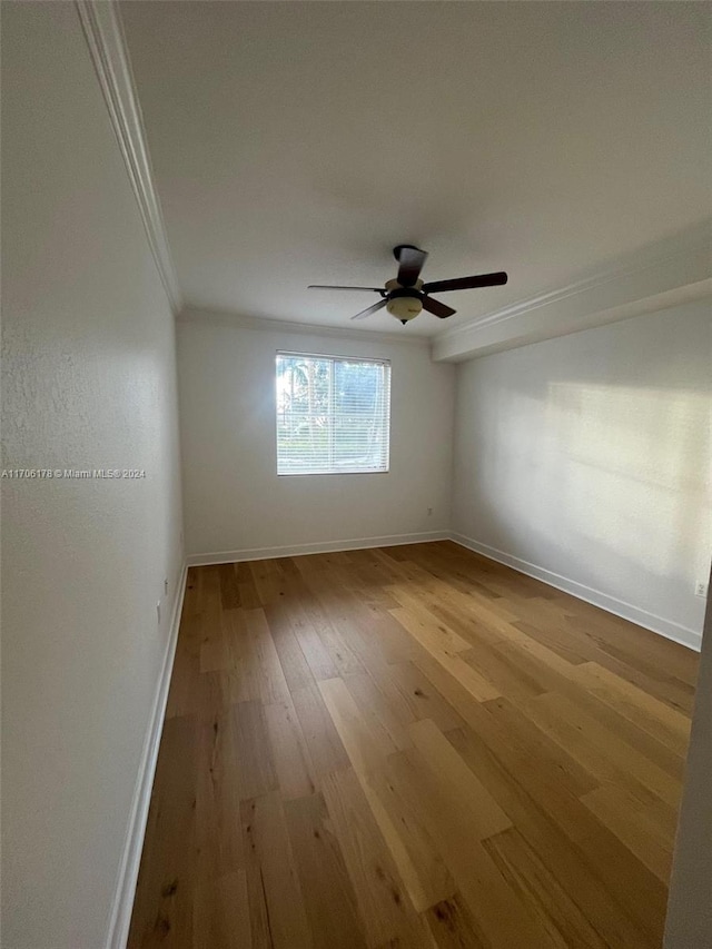 empty room featuring ceiling fan, light hardwood / wood-style floors, and ornamental molding