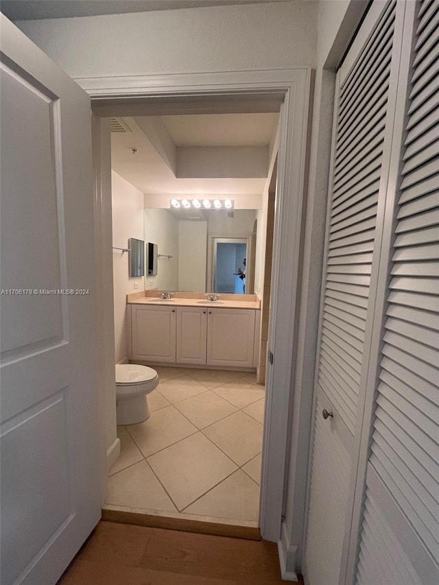 bathroom with toilet, vanity, and tile patterned floors