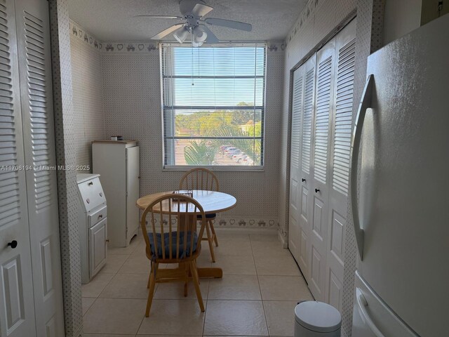 tiled dining room featuring ceiling fan and a textured ceiling