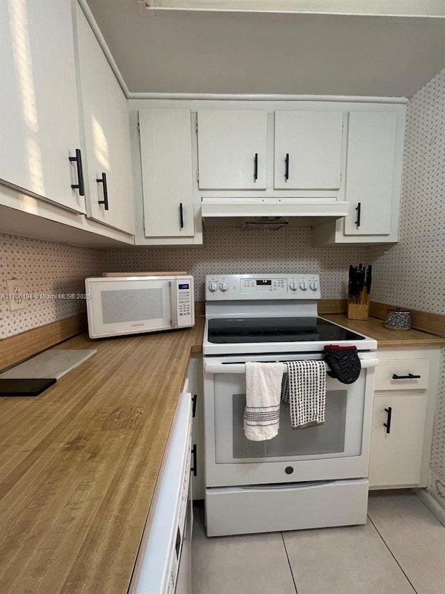 kitchen featuring under cabinet range hood, white cabinets, white appliances, and wallpapered walls