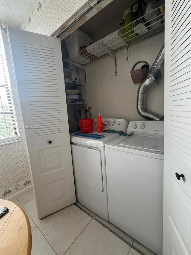 washroom featuring separate washer and dryer, laundry area, and light tile patterned floors