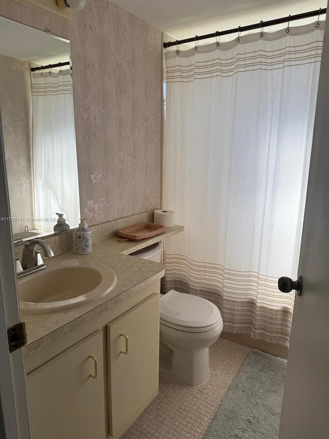 bathroom featuring toilet, tile patterned flooring, and vanity