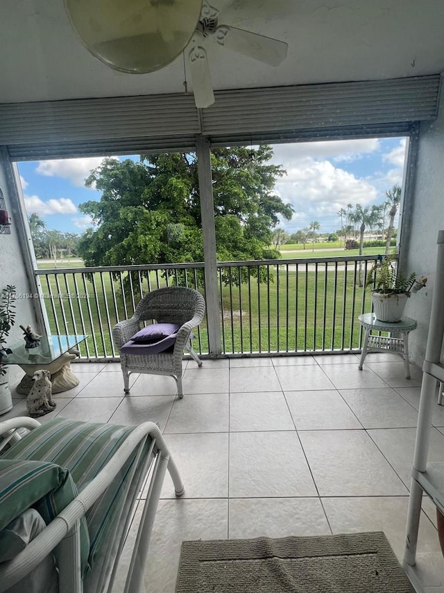 unfurnished sunroom with ceiling fan