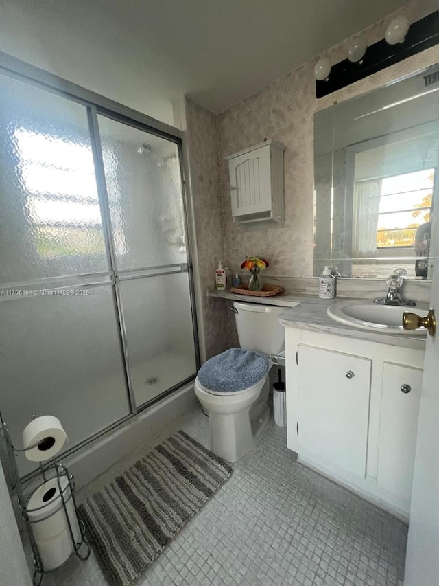 full bath with vanity, toilet, tile patterned flooring, and a stall shower