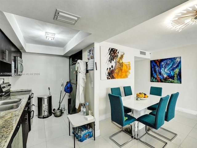 tiled dining space with a tray ceiling