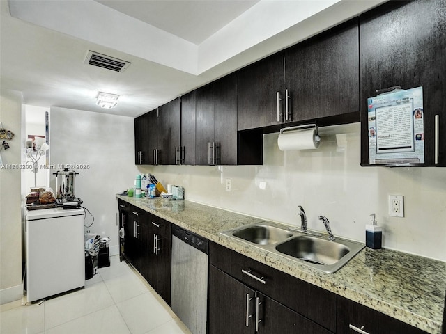 kitchen featuring dishwasher, light tile patterned floors, light stone counters, and sink