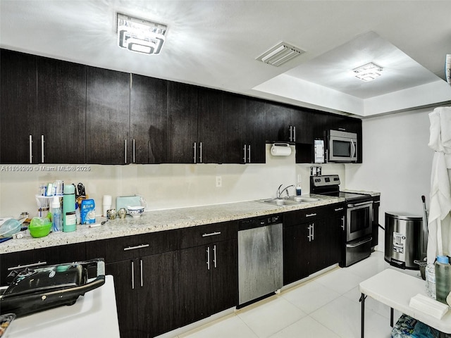 kitchen with appliances with stainless steel finishes, light tile patterned floors, and sink