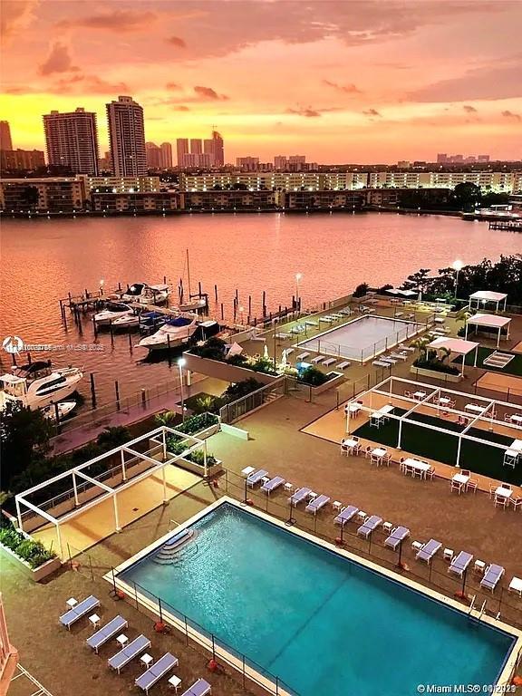 pool at dusk featuring a water view