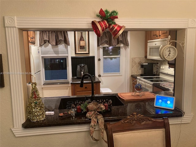 kitchen featuring decorative backsplash and white appliances