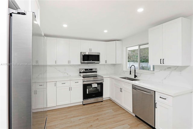 kitchen featuring white cabinets, stainless steel appliances, and sink