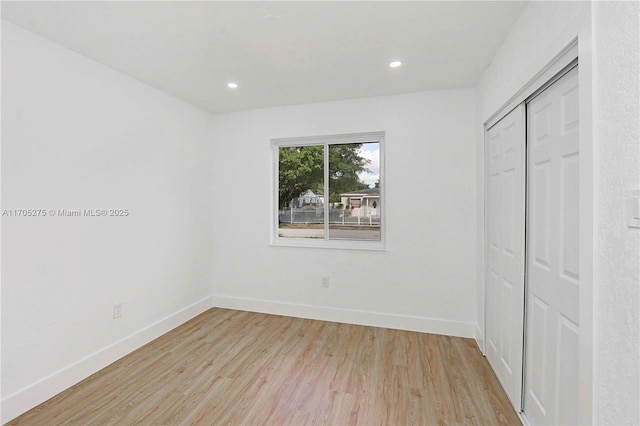 unfurnished bedroom with a closet and light hardwood / wood-style flooring