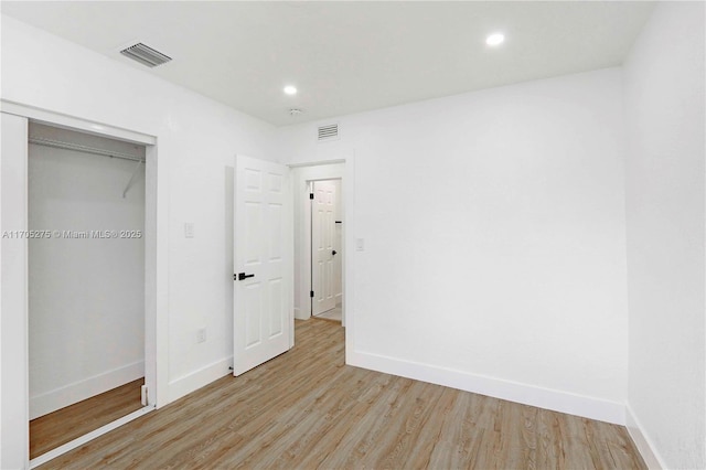 unfurnished bedroom with a closet and light wood-type flooring