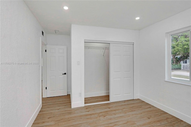 unfurnished bedroom featuring a closet and light hardwood / wood-style flooring