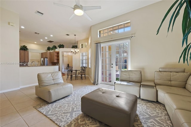 tiled living room featuring ceiling fan with notable chandelier and a healthy amount of sunlight