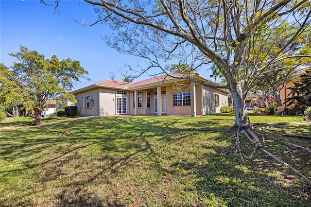 back of house with a yard and french doors