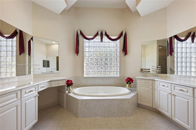 bathroom featuring tile patterned floors, vanity, a relaxing tiled tub, and a towering ceiling