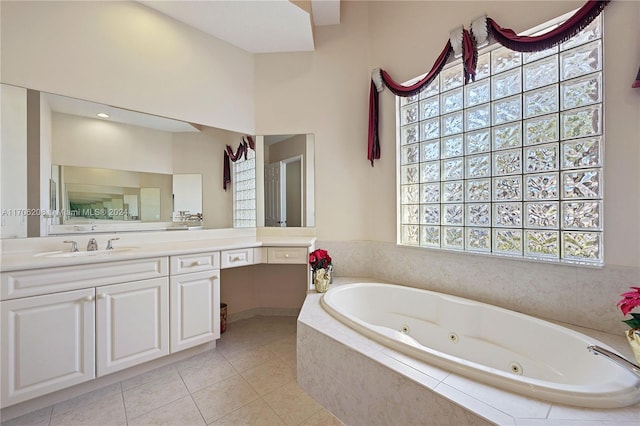 bathroom with tile patterned flooring, vanity, and a relaxing tiled tub