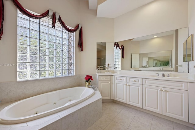 bathroom featuring tile patterned flooring, vanity, and a relaxing tiled tub