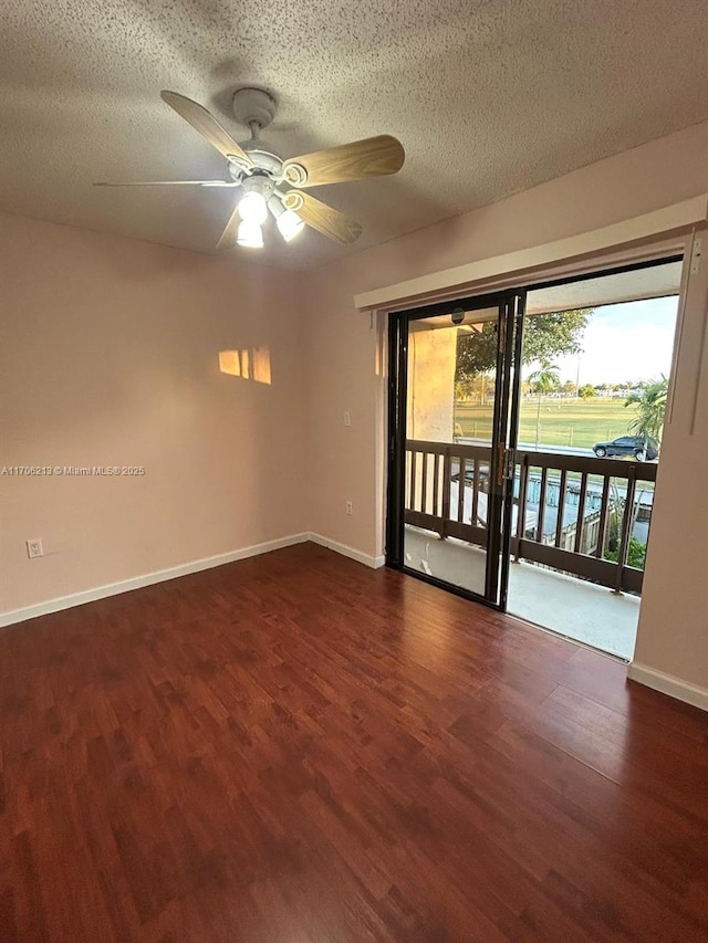 empty room featuring dark wood-type flooring, ceiling fan, and a textured ceiling